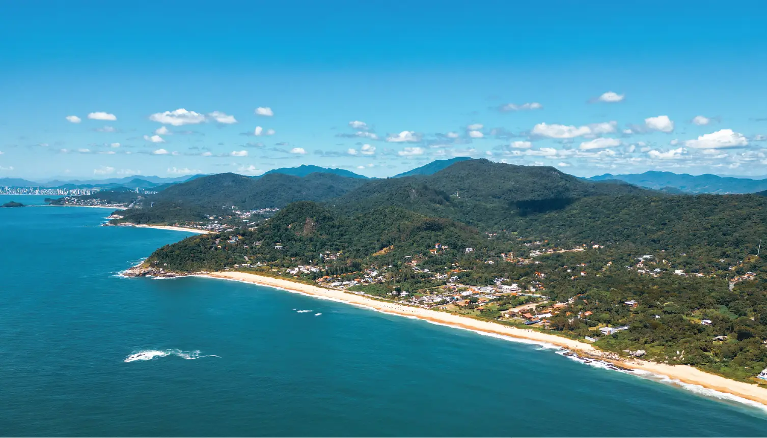 Vista aérea da região litorânea onde atua a ABF Vaccaro, com praia e mata nativa